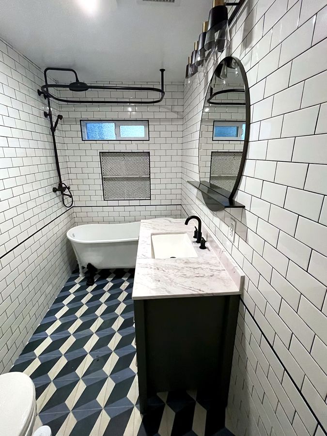 Classic bath remodel with subway tile, clawfoot tub, and patterned floor
