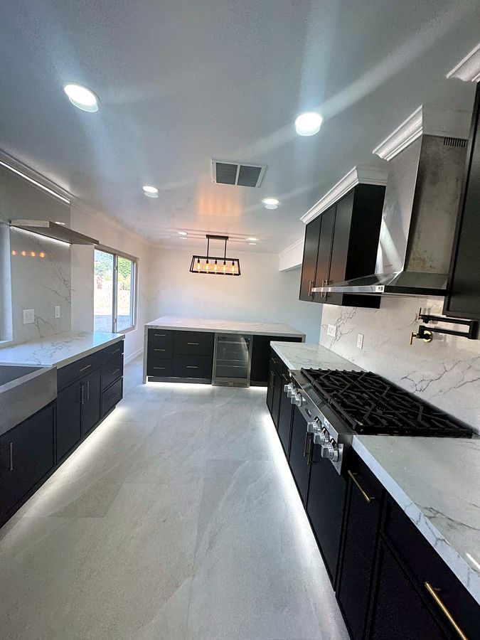 Kitchen with marble island, professional range, and statement fixtures