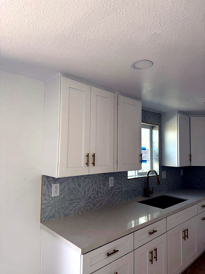 White shaker kitchen with brass hardware and gold faucet