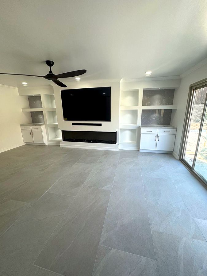 Living room with custom built-in media wall and ceiling fan