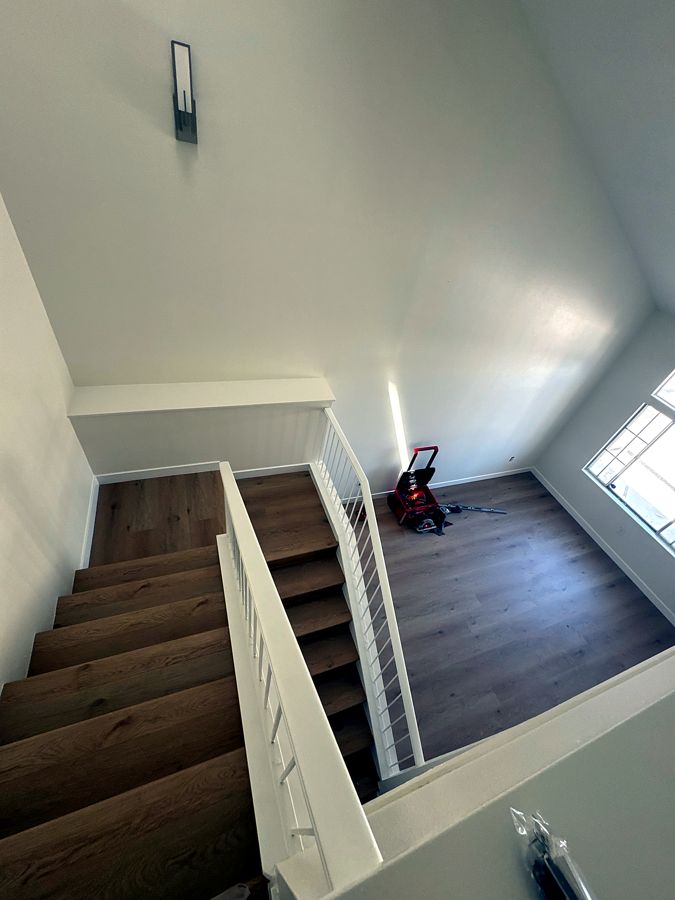 Staircase and loft with wide-plank wood flooring