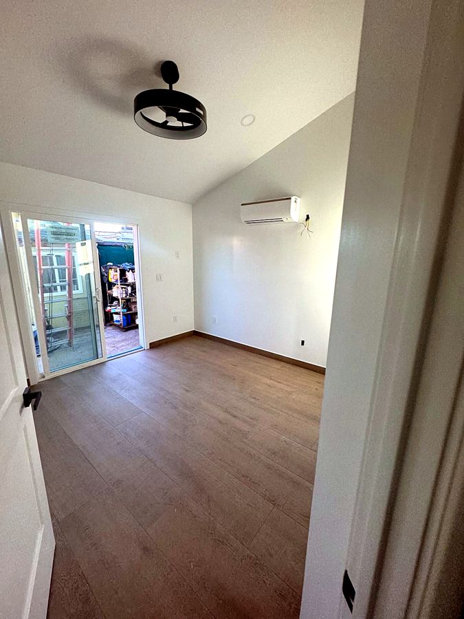 Remodeled living space with new flooring and sliding glass door